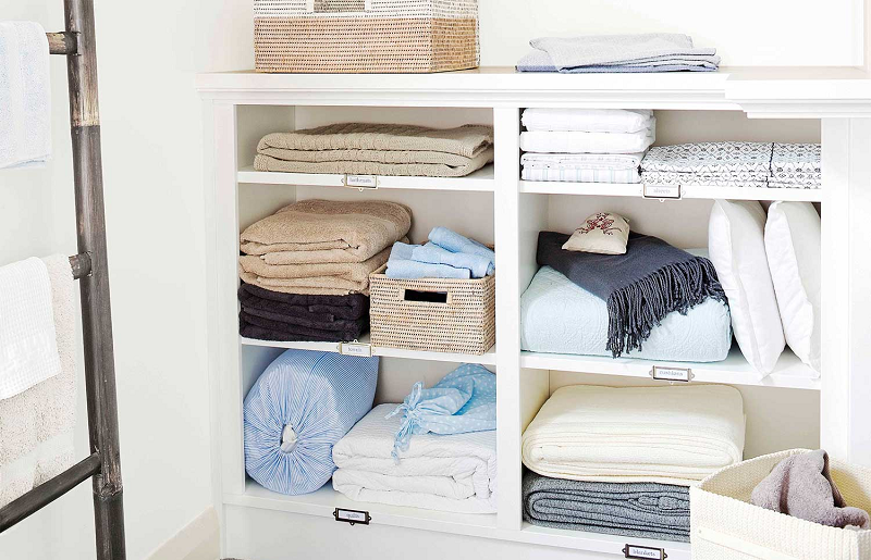 Roupas de cama e banho organizadas em prateleiras